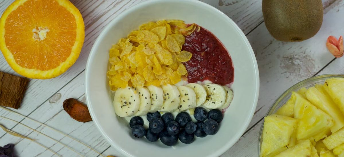 A vibrant breakfast bowl with fresh fruits and cereal on a wooden table.