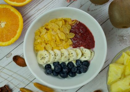 A vibrant breakfast bowl with fresh fruits and cereal on a wooden table.