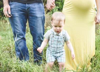 man in black tank top carrying baby in blue and white plaid button up shirt
